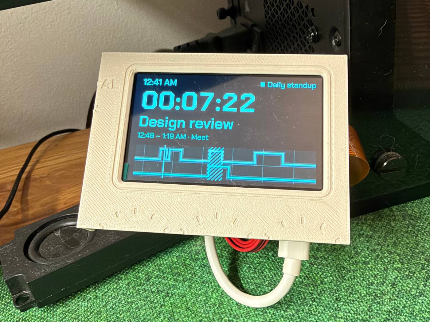 The screen running the demo schedule, seated in a printed frame that is just the middle of the front panel